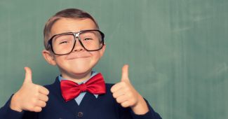 Close up portrait of child giving two thumbs up